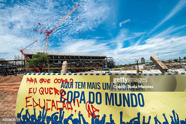 Graffiti demanding better education and public spending is written across a 'World Cup' banner outside the Arena Pantanal stadium under construction...
