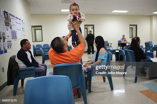 An immigrant detainee holds his daughter during a family visitation visit at the Adelanto Detention Facility on November 15, 2013 in Adelanto,...