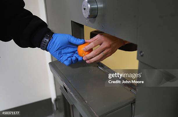 Guard serves desert to an immigrant detainee in his 'segregation cell' during lunchtime at the Adelanto Detention Facility on November 15, 2013 in...