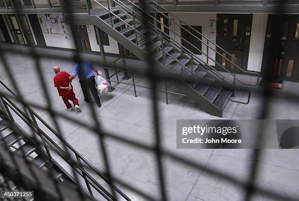 Guard escorts an immigrant detainee from his 'segregation cell' back into the general population at the Adelanto Detention Facility on November 15,...