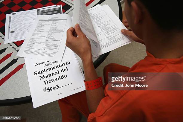 An immigrant detainee reads through paperwork in a general population block at the Adelanto Detention Facility on November 15, 2013 in Adelanto,...