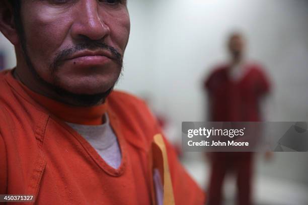 Immigrants wait in a processing cell at the Adelanto Detention Facility on November 15, 2013 in Adelanto, California. The center, the largest and...