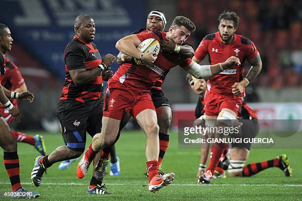Wales wing Alex Cuthbert is tackled by Eastern Province Kings' Hooker Edgar Marutlulle during the international friendly rugby union match between...