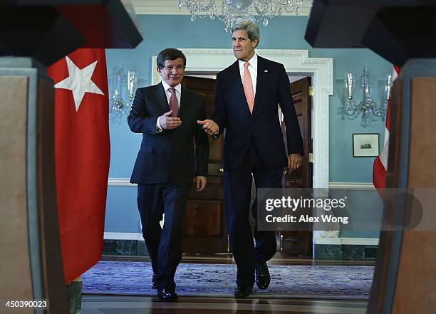 Secretary of State John Kerry and Turkish Foreign Minister Ahmet Davutoglu walk towards the podiums for a joint press availability November 18, 2013...