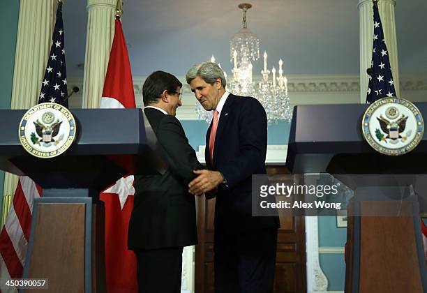 Secretary of State John Kerry and Turkish Foreign Minister Ahmet Davutoglu shake hands during a joint press availability November 18, 2013 at the...