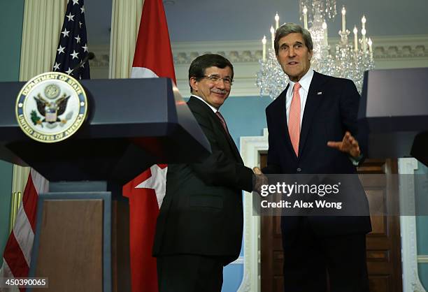 Secretary of State John Kerry and Turkish Foreign Minister Ahmet Davutoglu shake hands during a joint press availability November 18, 2013 at the...