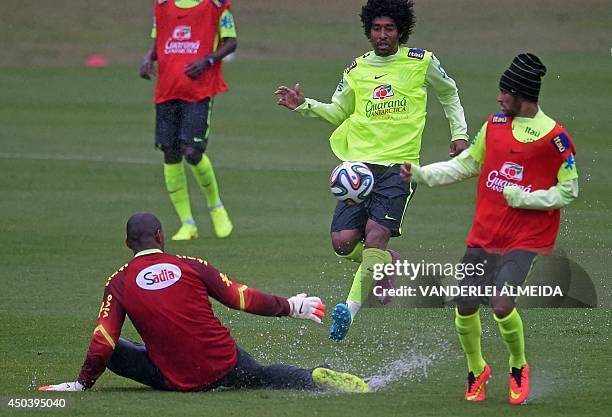 Brazilian national football team players goalkeeper Jefferson, defender Dante and striker Neymar vie for the ball during a training session of the...