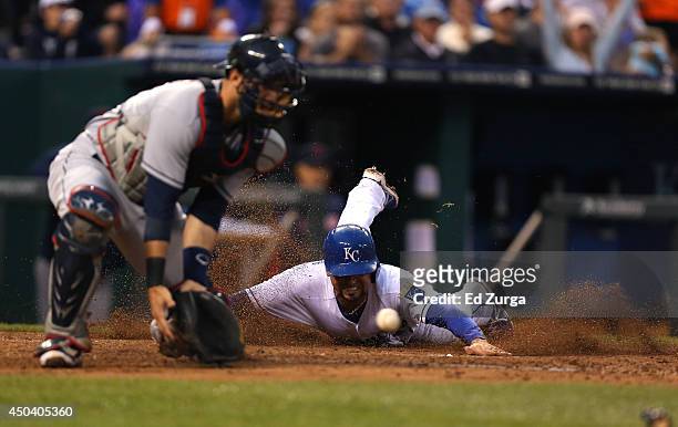 Omar Infante of the Kansas City Royals slides into home to score on a Billy Butler single as Yan Gomes of the Cleveland Indians fields the ball in...