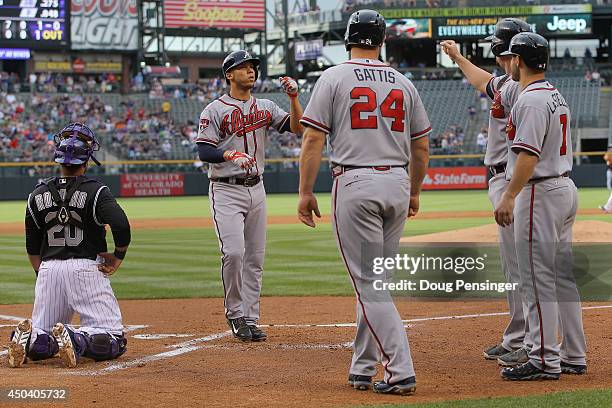 Andrelton Simmons of the Atlanta Braves is welcomed home after his grand slam home run off of starting pitcher Juan Nicasio of the Colorado Rockies...