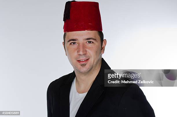 young man wearing a fez hat - fezes stock-fotos und bilder