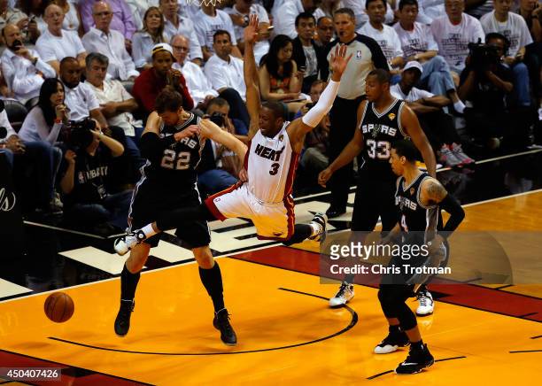 Dwyane Wade of the Miami Heat loses the ball as Tiago Splitter of the San Antonio Spurs defends during Game Three of the 2014 NBA Finals at American...