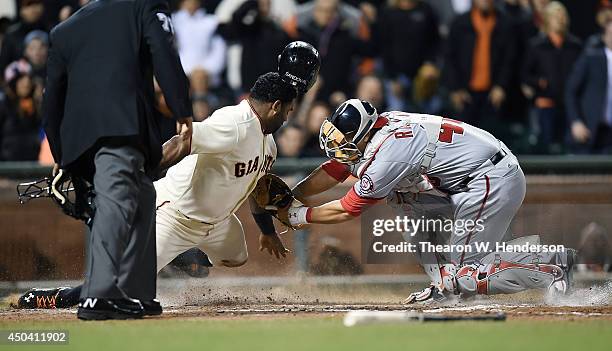 Pablo Sandoval of the San Francisco Giants is tagged out at home plate by catcher Wilson Ramos of the Washington Nationals in the bottom of the sixth...