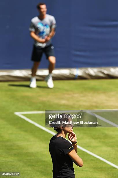 Amelie Mauresmo looks on as Andy Murray of Great Britain warms up on the practice courts on day three of the Aegon Championships at Queens Club on...