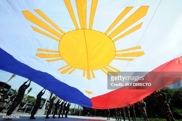 Members of the Philippine Army practice a flag-raising ceremony on the eve of the country's Independence Day at Luneta Park in Manila on June 11,...
