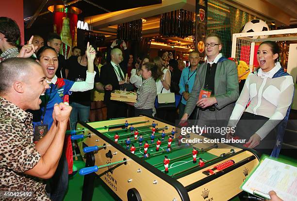 Anthony Callea celebrates as he scores a goal as Jesinta Campbell reacts at the Crown's Celebrity Foosball Cup on June 11, 2014 in Melbourne,...