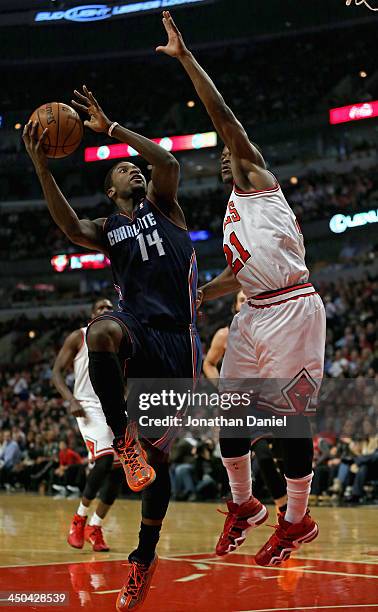 Michael Kidd-Golchrist of the Charlotte Bobcats drives against Jimmy Butler of the Chicago Bulls at the United Center on November 18, 2013 in...