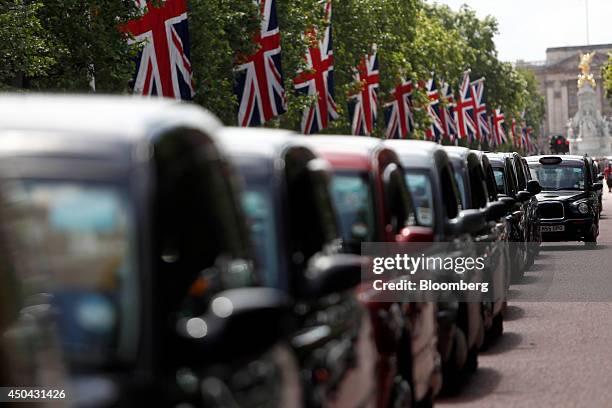 London taxi cabs stand parked along The Mall, leading away from Buckingham Palace, during a protest against Uber Technologies Inc.'s car sharing...