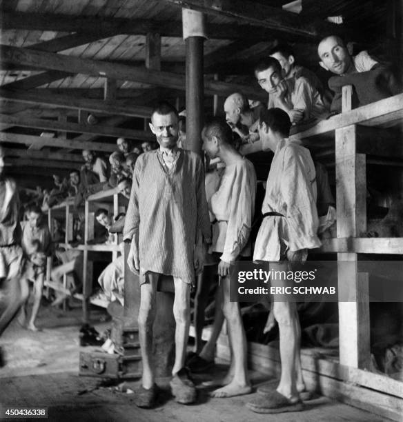 Prisoners, dressed in wooden shirts and clogs given to them upon arrival in the camp, look at the photographer in block 61 of Buchenwald nazi...