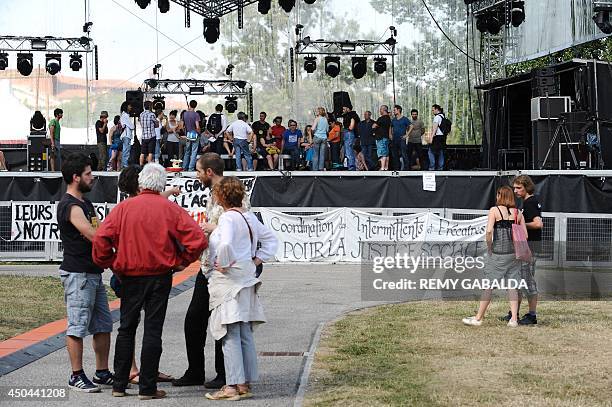 Entertainment industry workers and artists stand next to a banner hanging from a stage reading "Coordination of part-time entertainment industry...