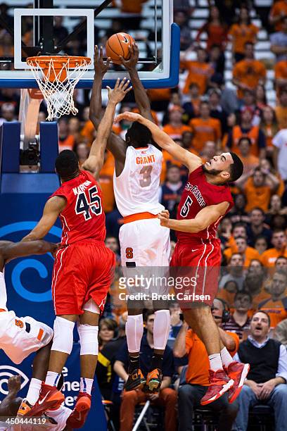 Jerami Grant of Syracuse Orange puts in a field goal in the second half while defenders Wayne Martin and Jalen Cannon of St Francis Terriers reach in...