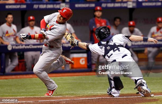 Allen Craig of the St. Louis Cardinals avoids the tag by catcher Ryan Hanigan of the Tampa Bay Rays as he runs home to score off of a two-run single...