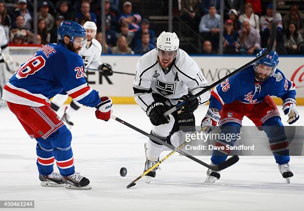 Anze Kopitar of the Los Angeles Kings tries to get past Dominic Moore and Martin St. Louis of the New York Rangers in the second period of Game Four...