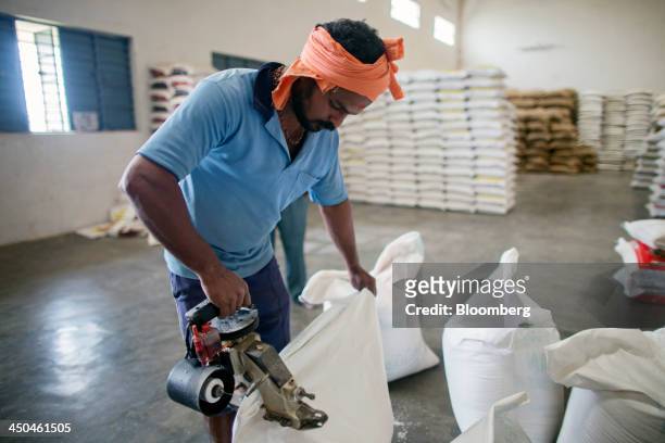 Workers seals a bags of rice at the KRK Modern Rice Mill in Kothapeta, Tamil Nadu, India, on Thursday, Nov. 14, 2013. Record onion prices and the...