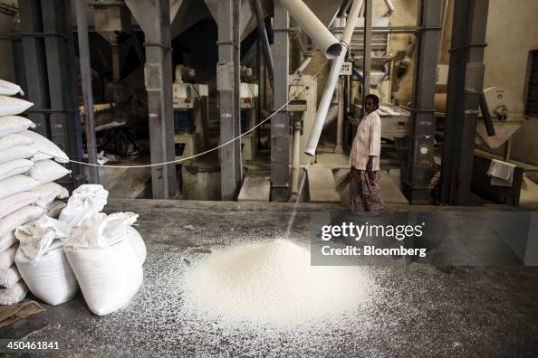 Soar Rice Rice pours from a polishing machine at the KRK Modern Rice Mill in ...