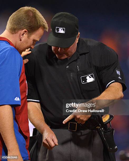 Umpire Tim Welke gets checked by a trainer in the eighth inning after getting hit by a pitch during the game between the San Diego Padres and...