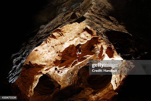 In this undated handout photo a spelunker explores the Riesending cave where an explorer is currently lying injured 1,000 meters below since June 8,...