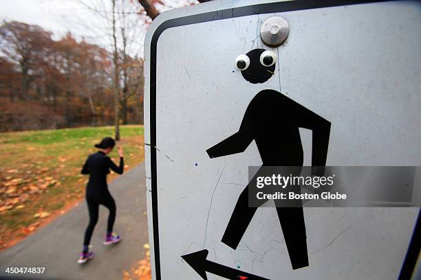 Passing jogger on the footpath is unaware of a vandal's mischievous placement of plastic bubble eyes on the signpost at the corner of Pond Avenue and...