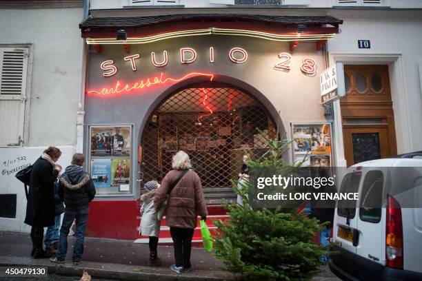 People wait to enter the Studio 28 cinema theater on January 12, 2011 in Paris. Lights were designed by French artist Jean Cocteau. AFP PHOTO LOIC...