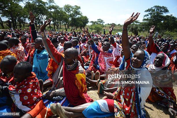 Kenyan Maasai women raise their hands as they gather during a meeting dedicated to the practice of female genital mutilation in which several...