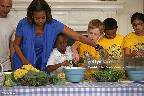 First lady Michelle Obama helps students from five District of Columbia schools make a meal using the summer crop from the White House Kitchen Garden...