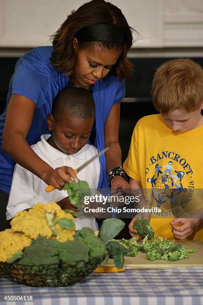 First lady Michelle Obama helps students from five District of Columbia schools make a meal using the summer crop from the White House Kitchen Garden...