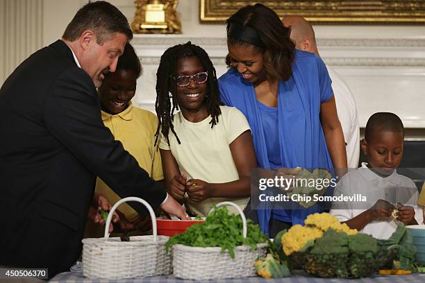 First lady Michelle Obama and West Virginia Department of Education Office of Child Nutrition Executive Director Richard Goff help students from five...