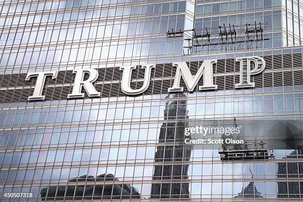 Workers install the final letter for a giant TRUMP sign on the outside of the Trump Tower on June 12, 2014 in Chicago, Illinois. Many in the city are...