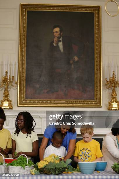 First lady Michelle Obama helps students from five District of Columbia schools make a meal using the summer crop from the White House Kitchen Garden...