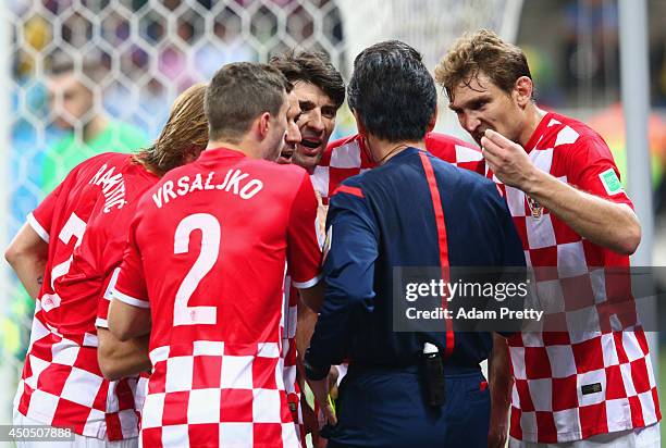 Referee Yuichi Nishimura is surrounded by Croatia players after awarding a penalty kick in the second half during the 2014 FIFA World Cup Brazil...