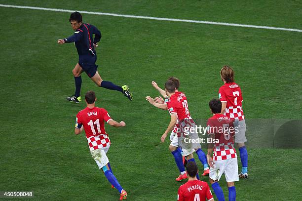 Yuichi Nishimura awards a penalty kick as Darijo Srna, Sime Vrsaljko, Luka Modric, Vedran Corluka and Ivan Rakitic of Croatia pursue him during the...