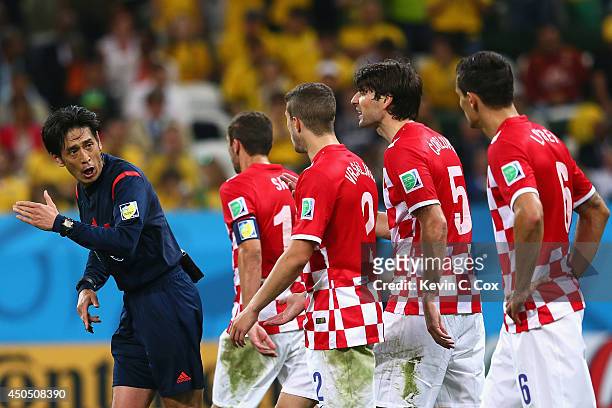Referee Yuichi Nishimura is pursued by Darijo Srna, Sime Vrsaljko, Vedran Corluka and Dejan Lovren of Croatia after awarding a penalty kick and...