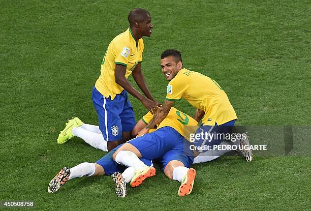 Teammates including defender Dani Alves , Fred and Brazil's midfielder Ramires mob Brazil forward Oscar after he scored during a Group A football...