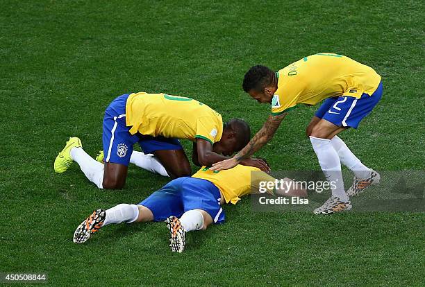 Oscar of Brazil lies on the ground celebrating his goal with Ramires and Dani Alves in the second half during the 2014 FIFA World Cup Brazil Group A...