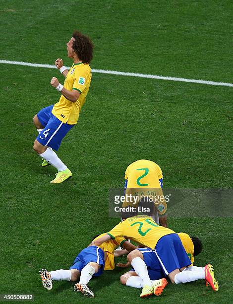 Oscar of Brazil lies on the ground celebrating his goal with David Luiz, Ramires and Dani Alves in the second half during the 2014 FIFA World Cup...