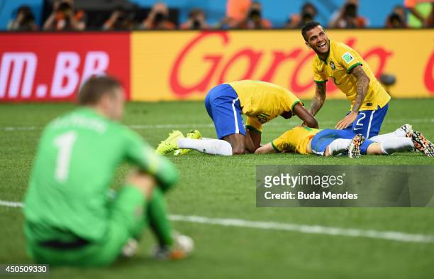 Oscar of Brazil lies on the ground celebrating his goal with Ramires and Dani Alves as Stipe Pletikosa of Croatia sits looking on in the second half...