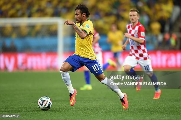 Brazil's forward Neymar dribbles the ball during a Group A football match between Brazil and Croatia at the Corinthians Arena in Sao Paulo during the...