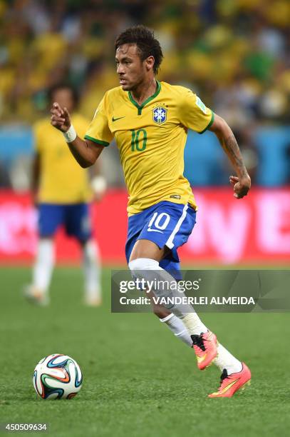 Brazil's forward Neymar dribbles the ball during a Group A football match between Brazil and Croatia at the Corinthians Arena in Sao Paulo during the...