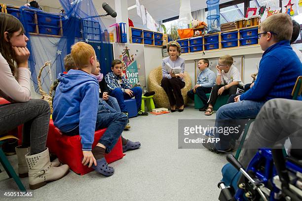 Belgium's Queen Mathilde talks to children on November 18, 2013 during a visit to the UZ Leuven hospital in Leuven, part of the aloud reading week,...