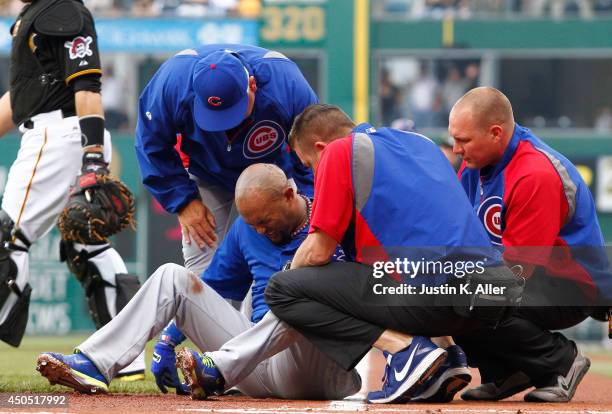 Emilio Bonifacio of the Chicago Cubs is tended to by medical staff in the first inning during the game against the Pittsburgh Pirates at PNC Park on...