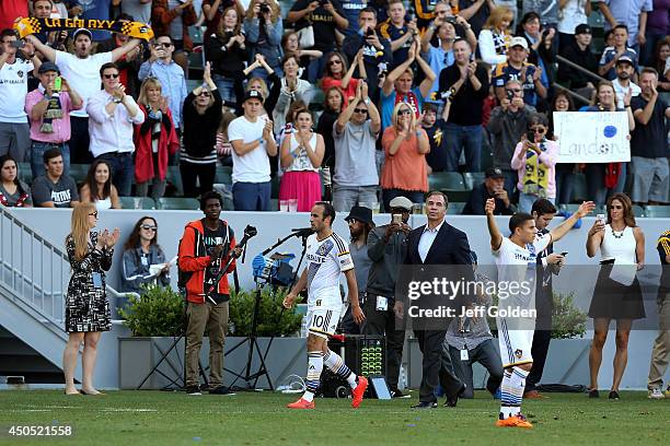 Landon Donovan of the Los Angeles Galaxy walks to the bench to a standing ovation followed by head coach Bruce Arena after being substituted out...